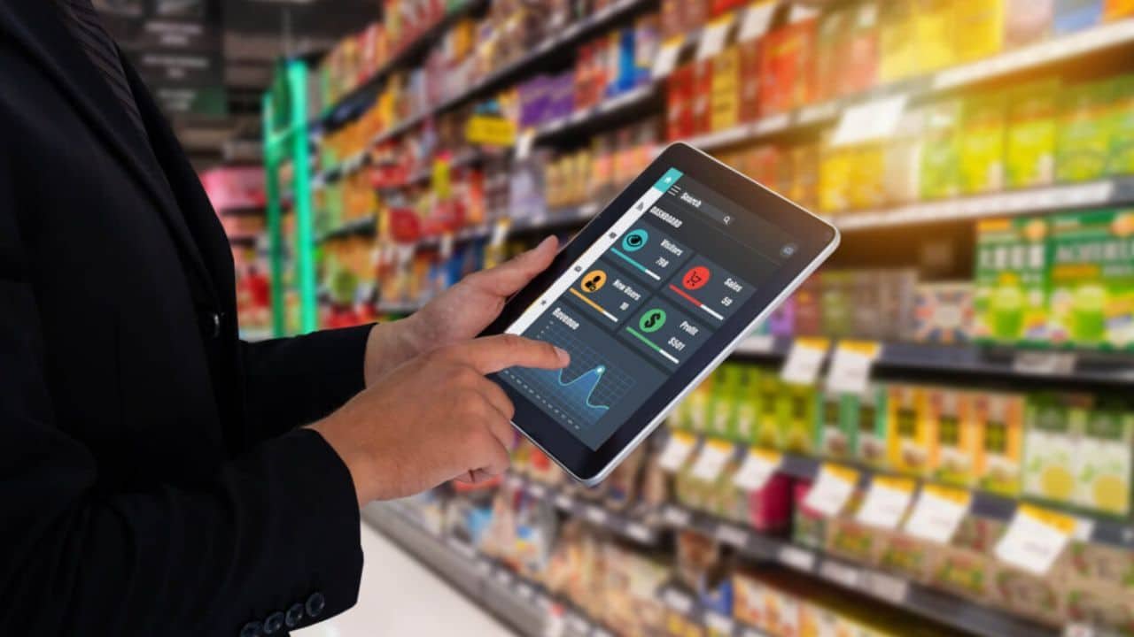 Small business owner reviewing an AI automation playbook on a tablet in their shop